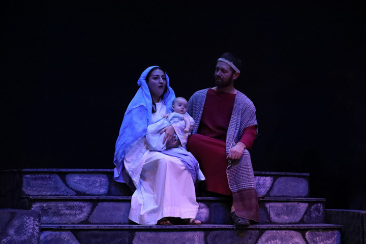 Mary holding baby Jesus and Joseph are seated.
